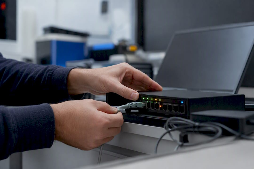 Hands connecting network cable to AI incident device