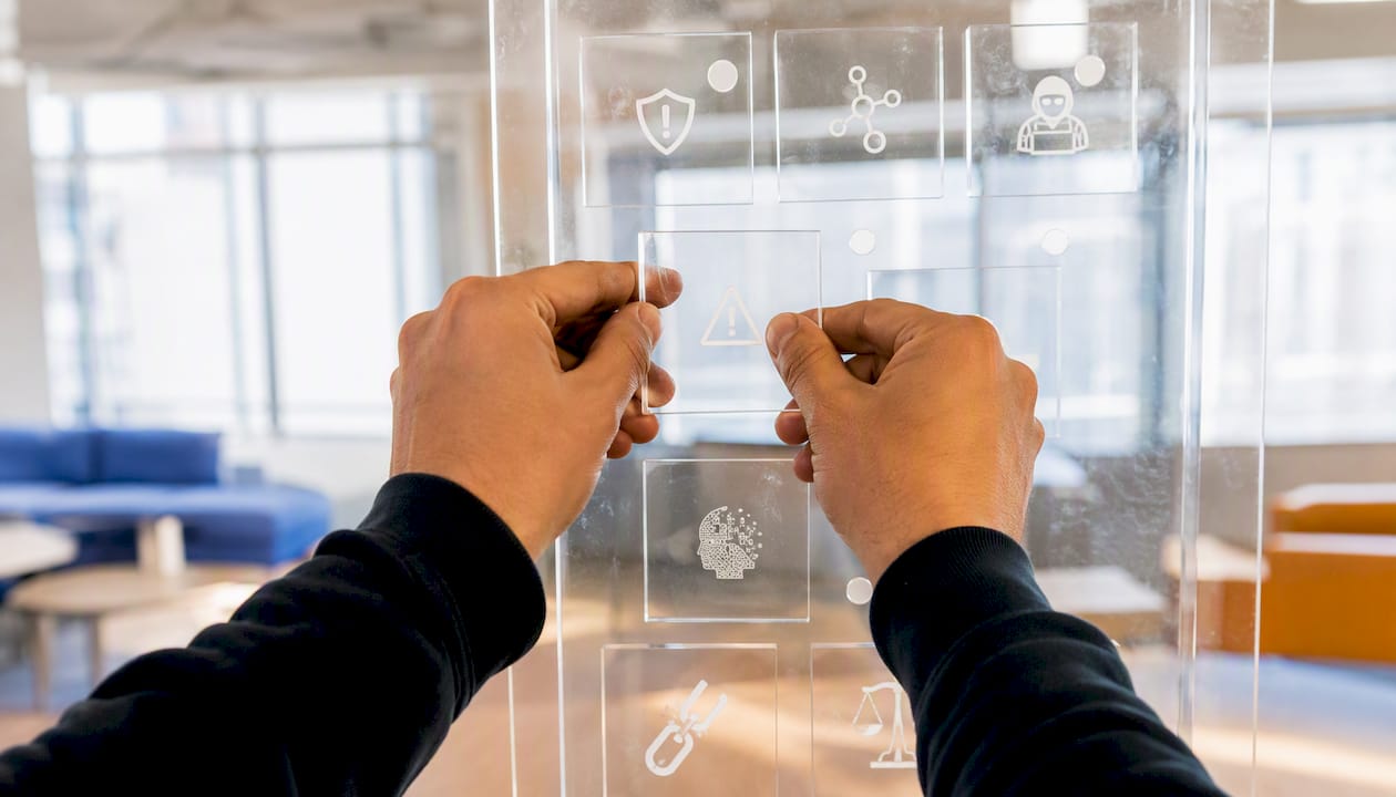 Hands classifying AI risk taxonomy on transparent sheets