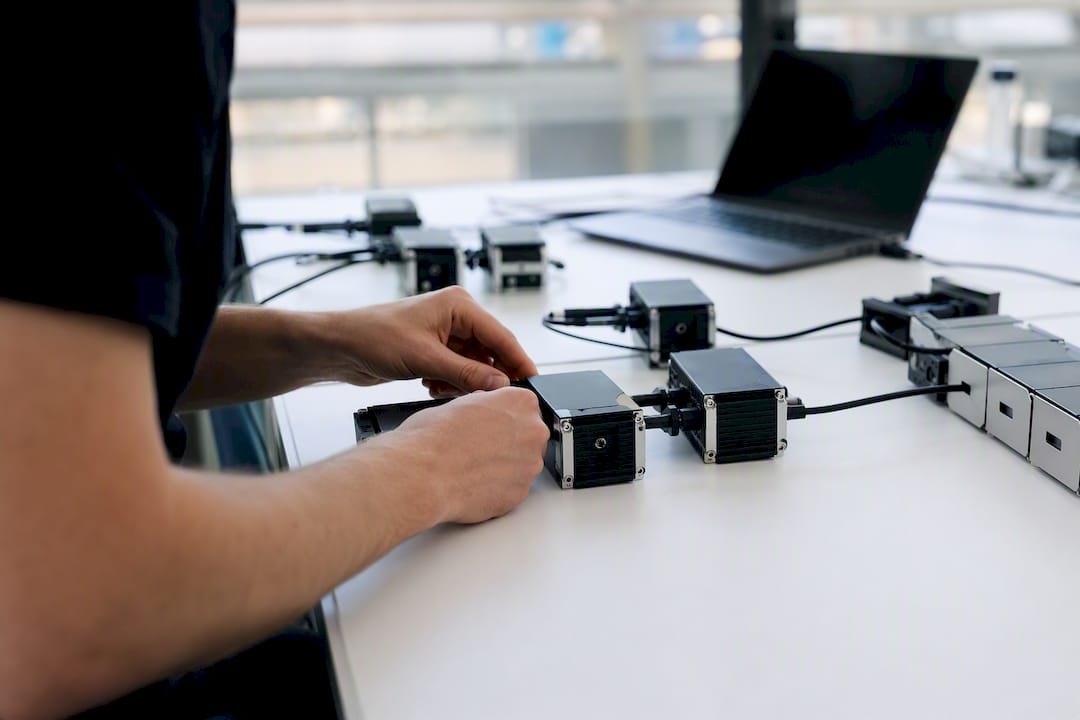Hands connecting modular components on workbench