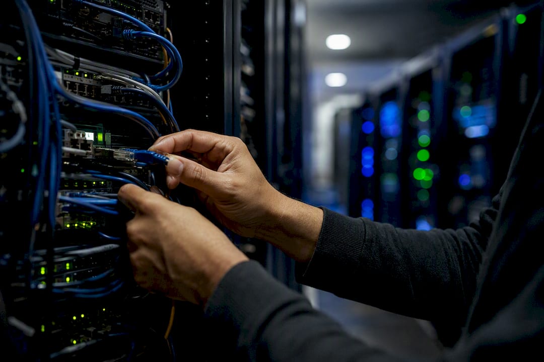 Hands connecting server cable in data center